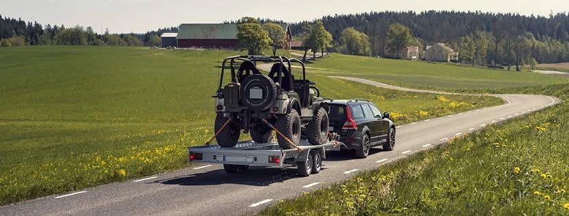 Autotrailer mit verladenem Fahrzeug und Auffahrrampen